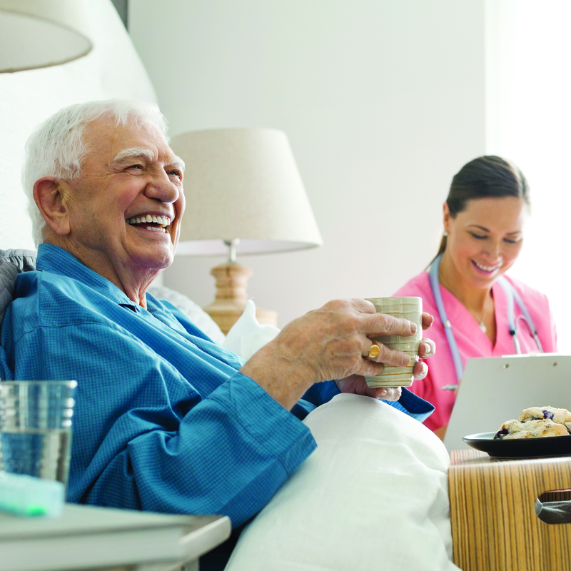 Smiling elderly man in hospital bed at Northlake Gastroenterology Associates.