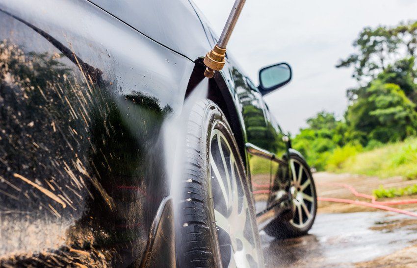 jet wash spraying water to clean the wheels of a vehicle