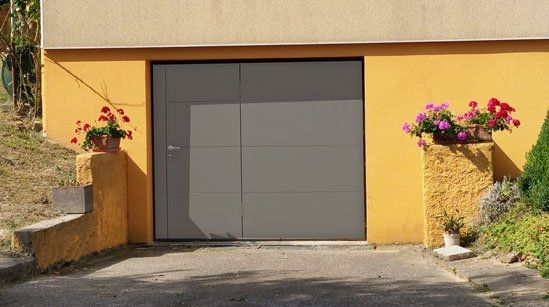 Porte alu grise avec accès pieton réalisation trihome