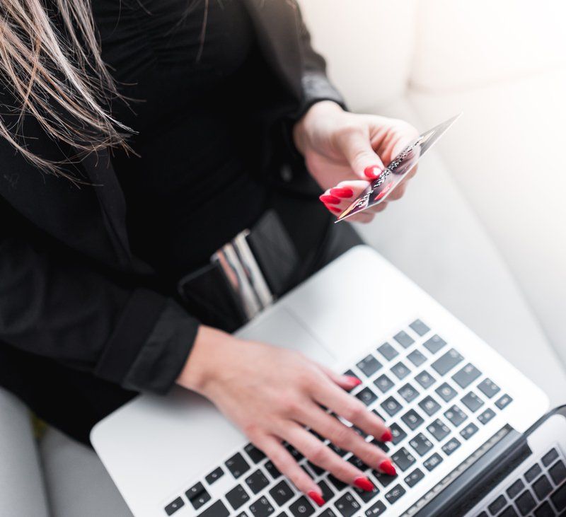 Woman entering credit card information on computer Woman entering credit card information on computer