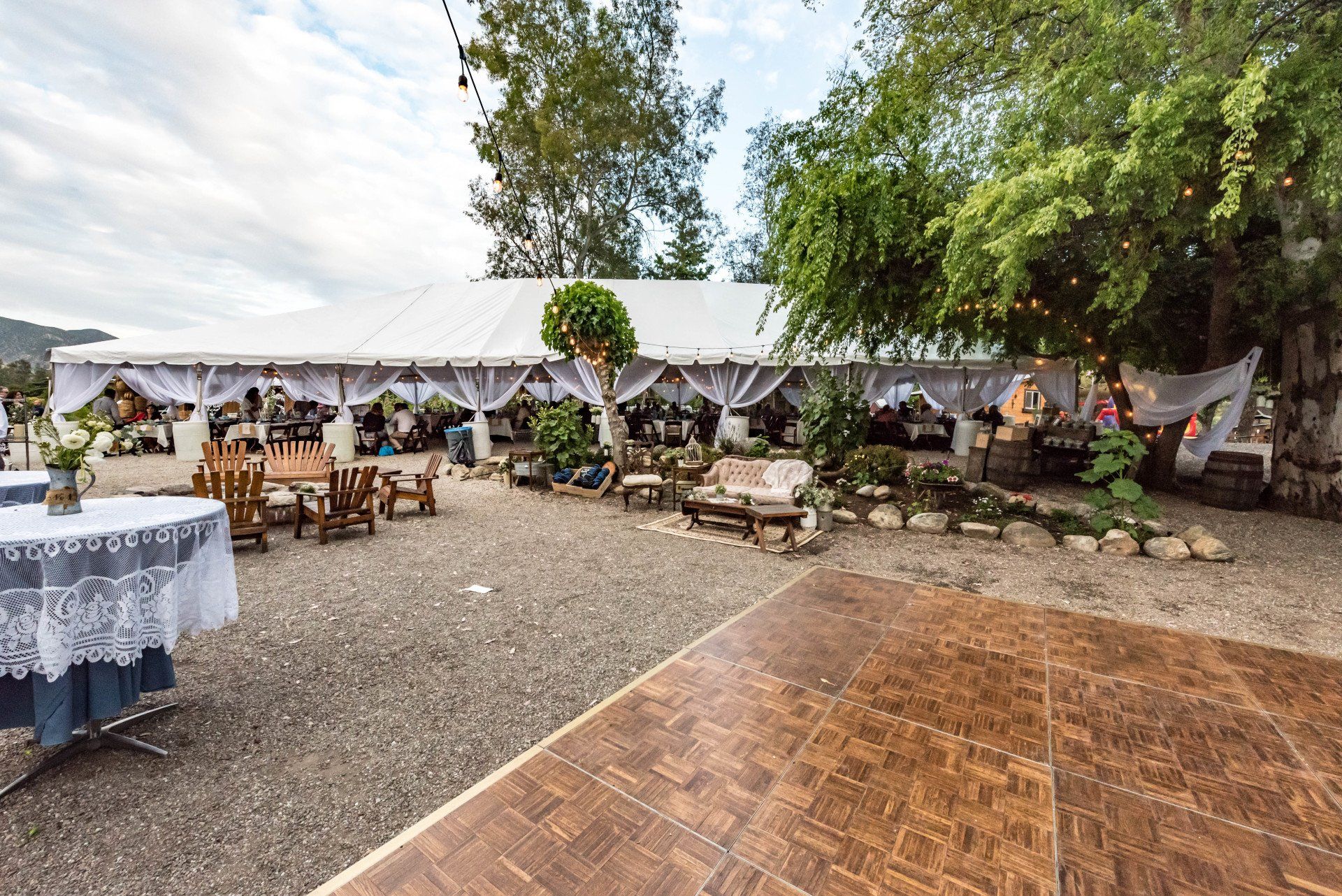 A wooden dance floor in front of a large tent.