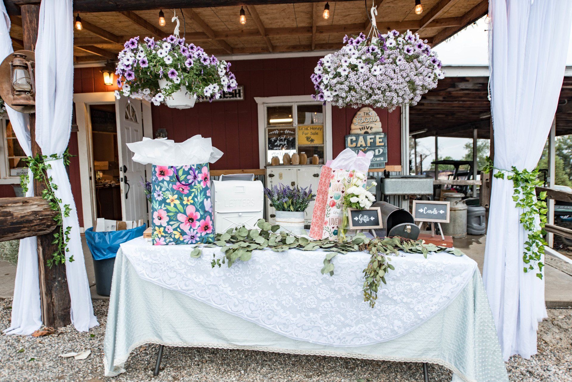 A table with flowers and gifts on it in front of a building.