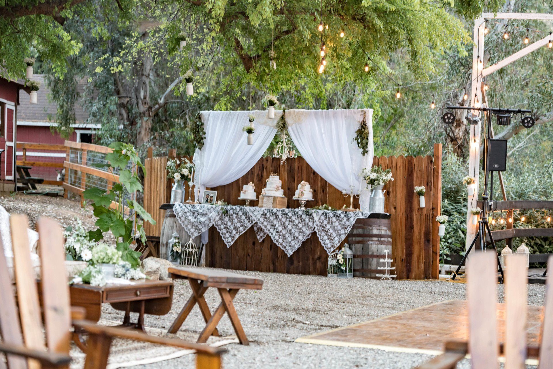 A table with a cake on it is sitting in front of a wooden fence.