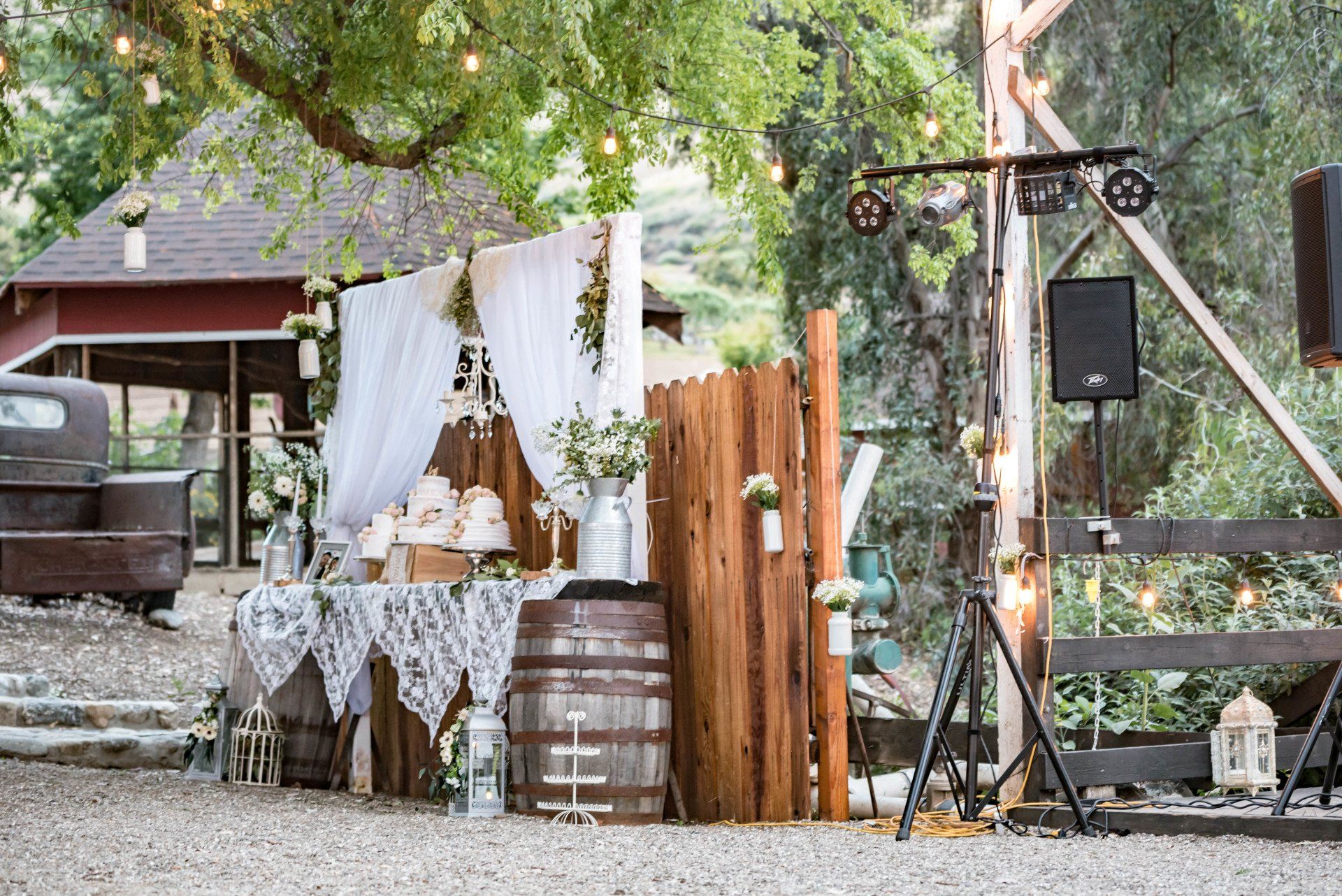 A wooden fence with a table and barrels in front of it.