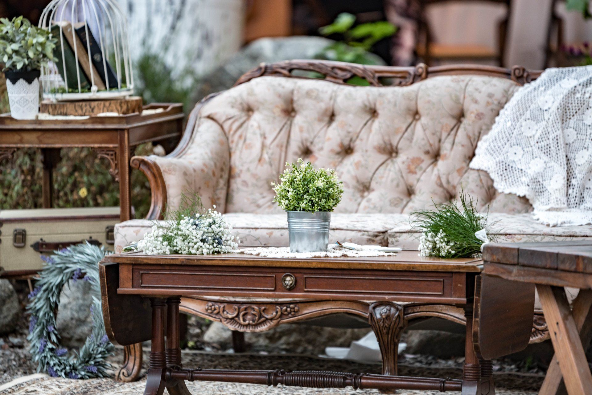 A couch is sitting on top of a wooden table with a potted plant on it.