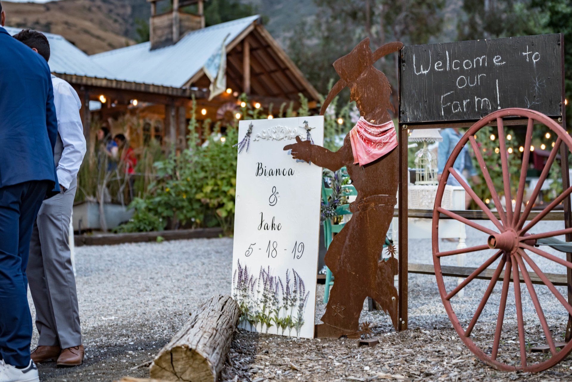 A group of people are standing in front of a sign that says welcome to our farm.
