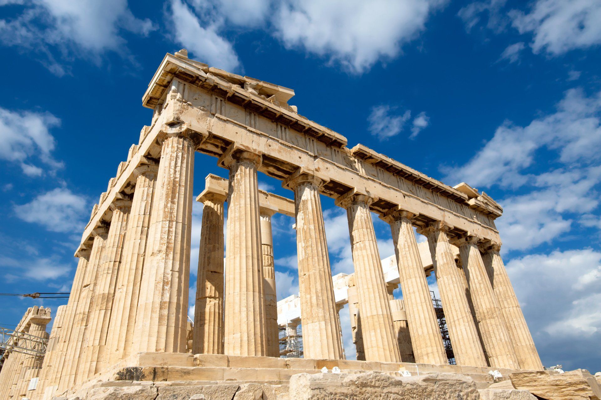 A very old building with columns and a blue sky in the background