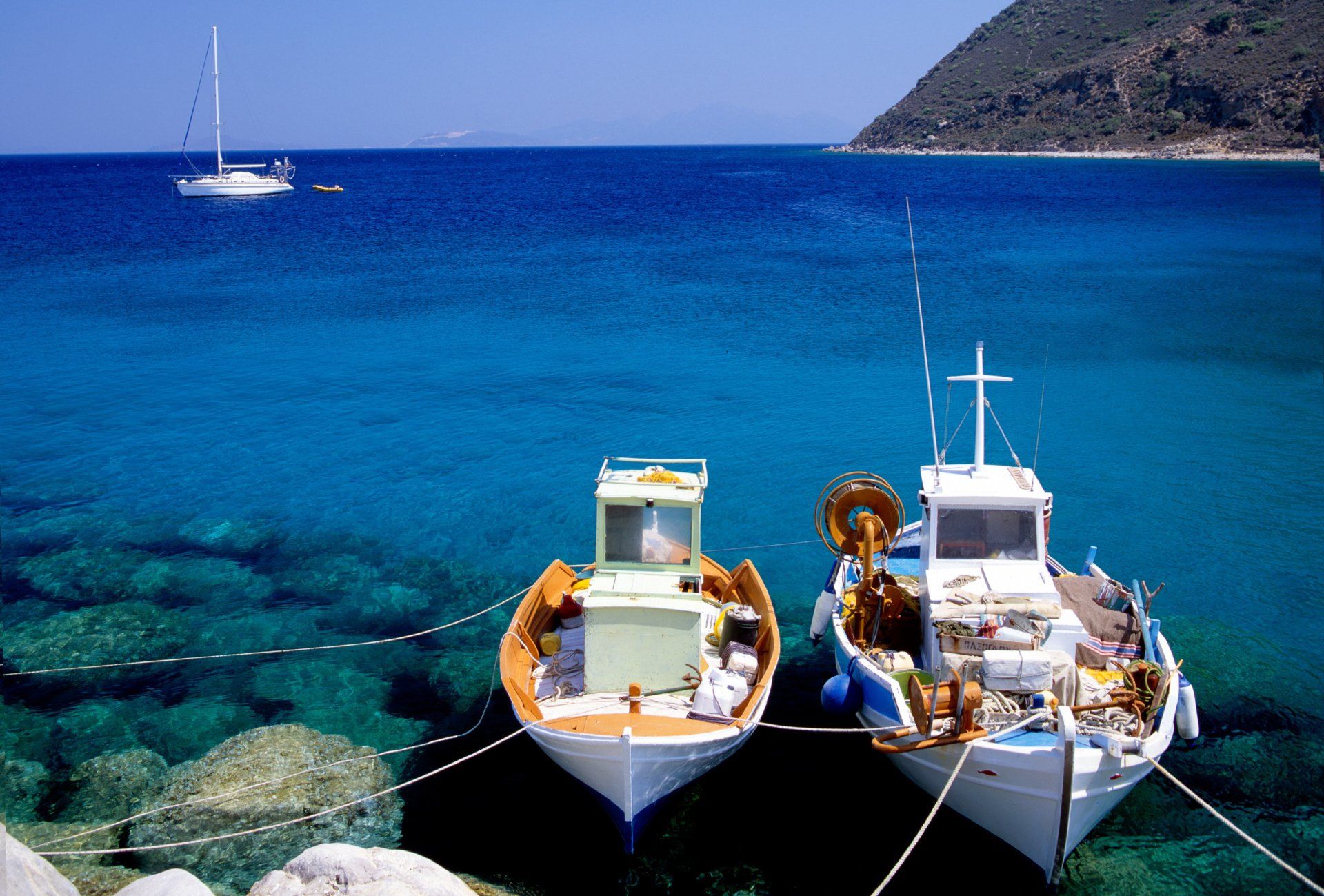 Two boats are tied to a dock in the ocean