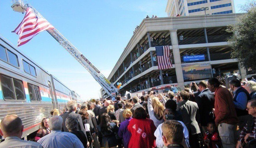 A crowd of people are gathered in front of a building with an american flag
