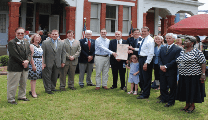 A group of people are posing for a picture in front of a house