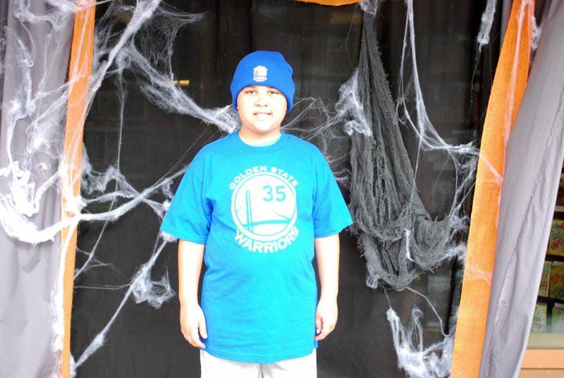 A young boy wearing a blue shirt with the number 35 on it