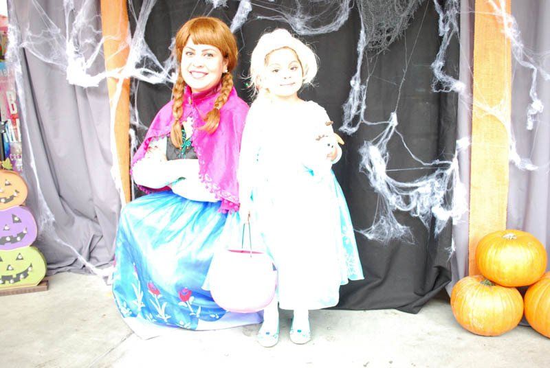 Two little girls dressed as anna and elsa are posing for a picture
