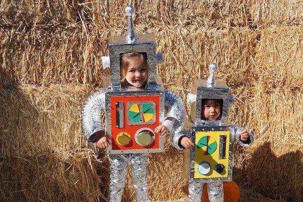 Two children dressed in robot costumes are standing next to each other