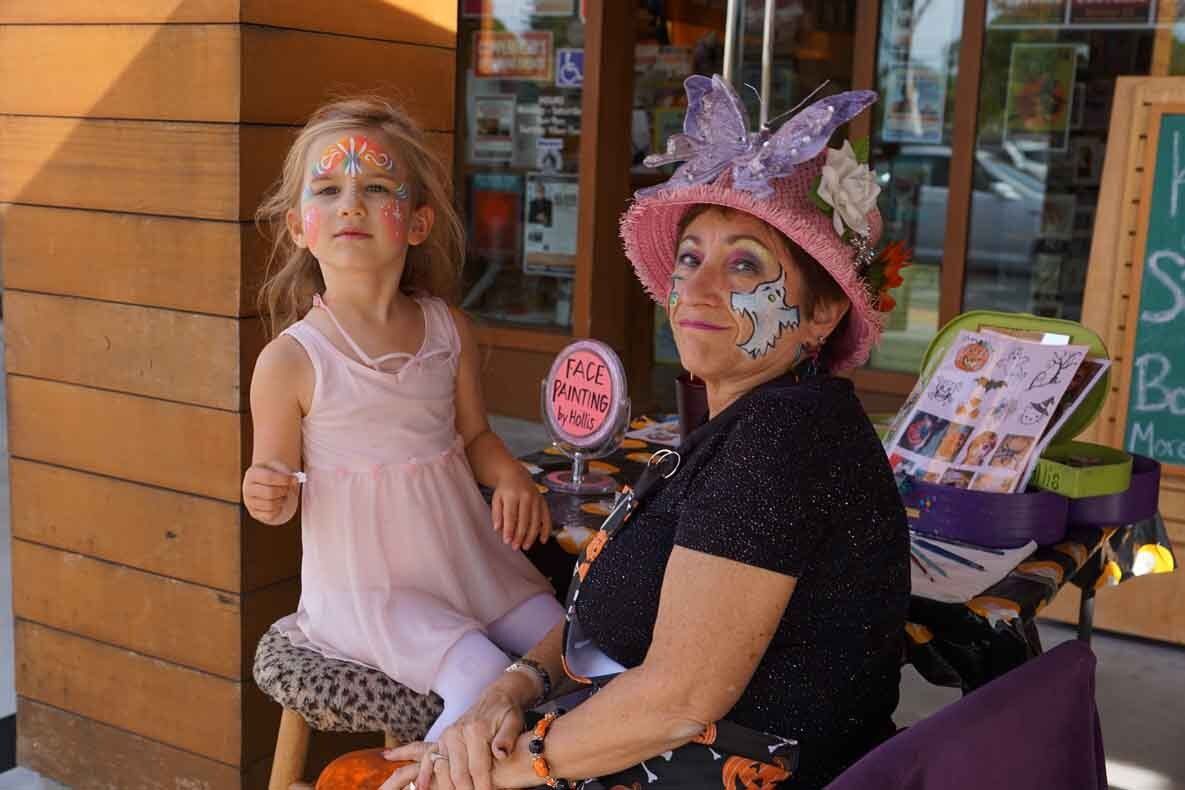 A woman and a little girl with face paint on their faces.