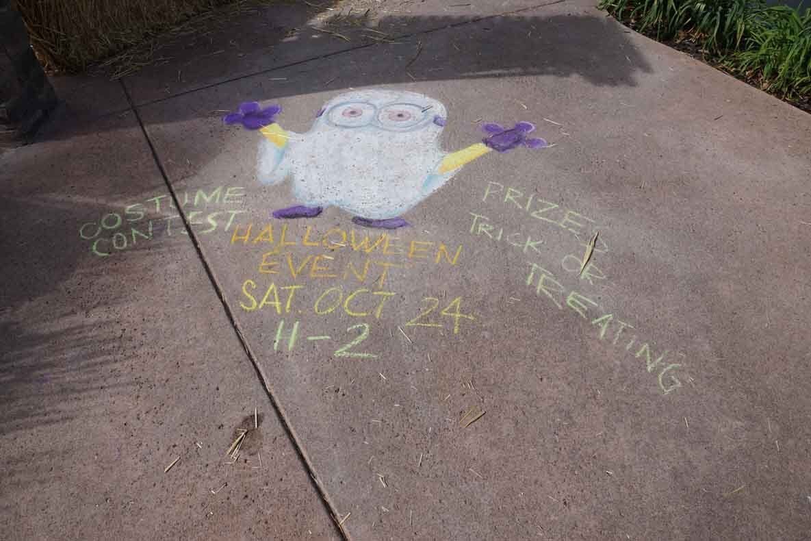 A chalk drawing of a minion on a sidewalk.