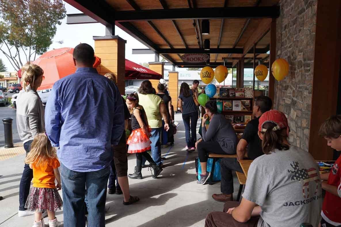 A group of people are standing outside of a restaurant.