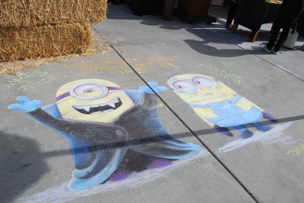 A chalk drawing of two minions on a sidewalk