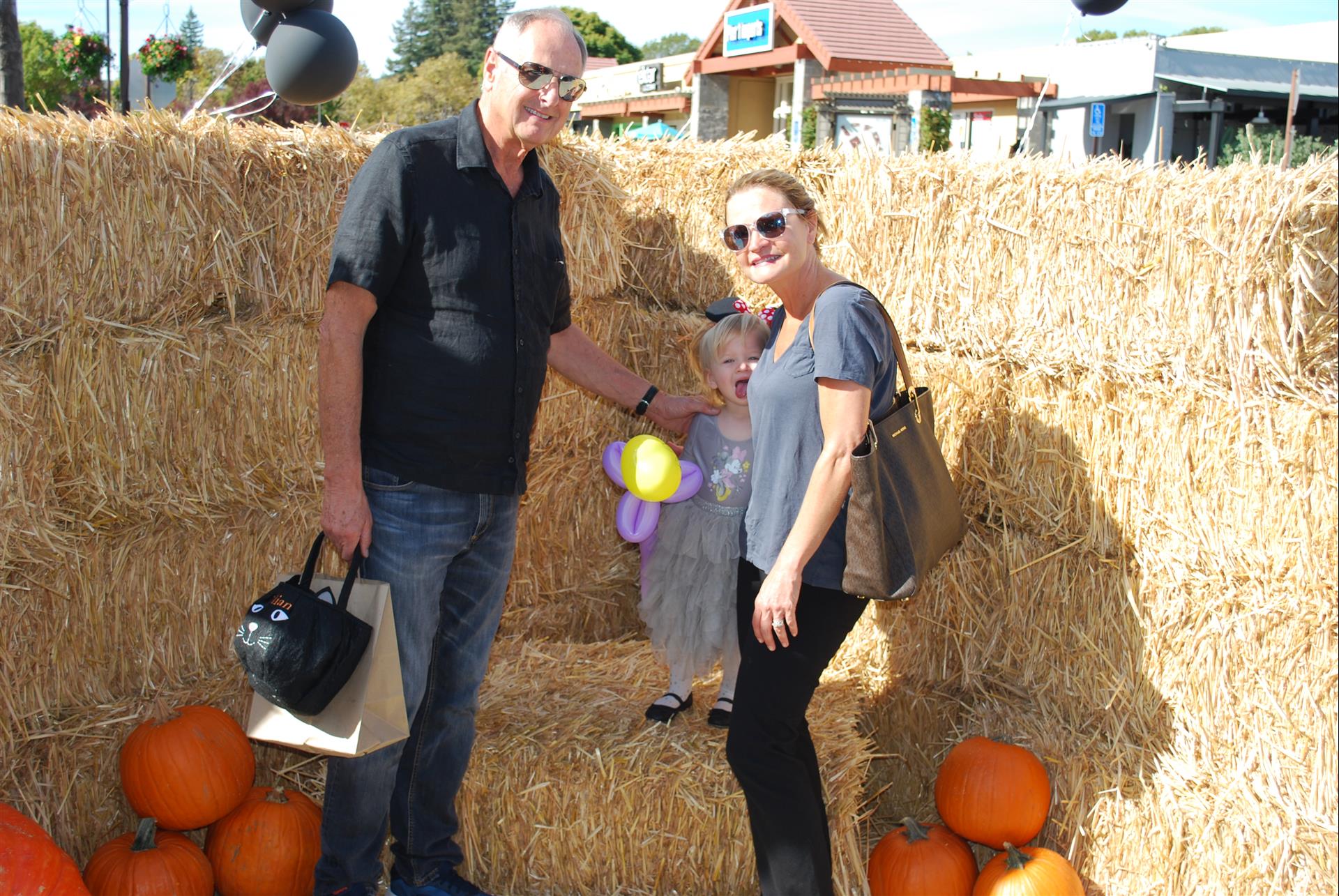 A man and a woman standing next to a pile of hay