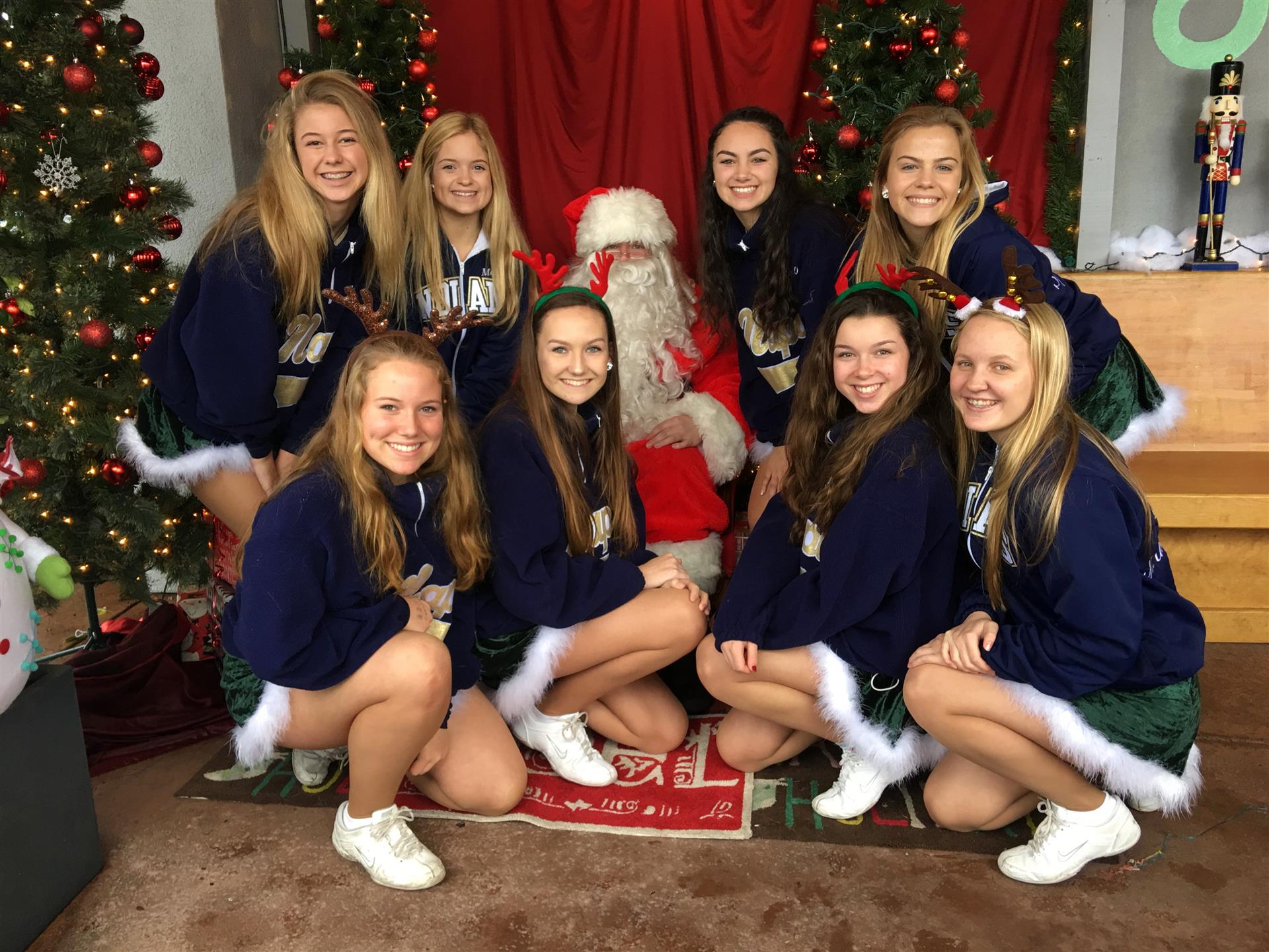 A group of girls are posing for a picture with santa claus.