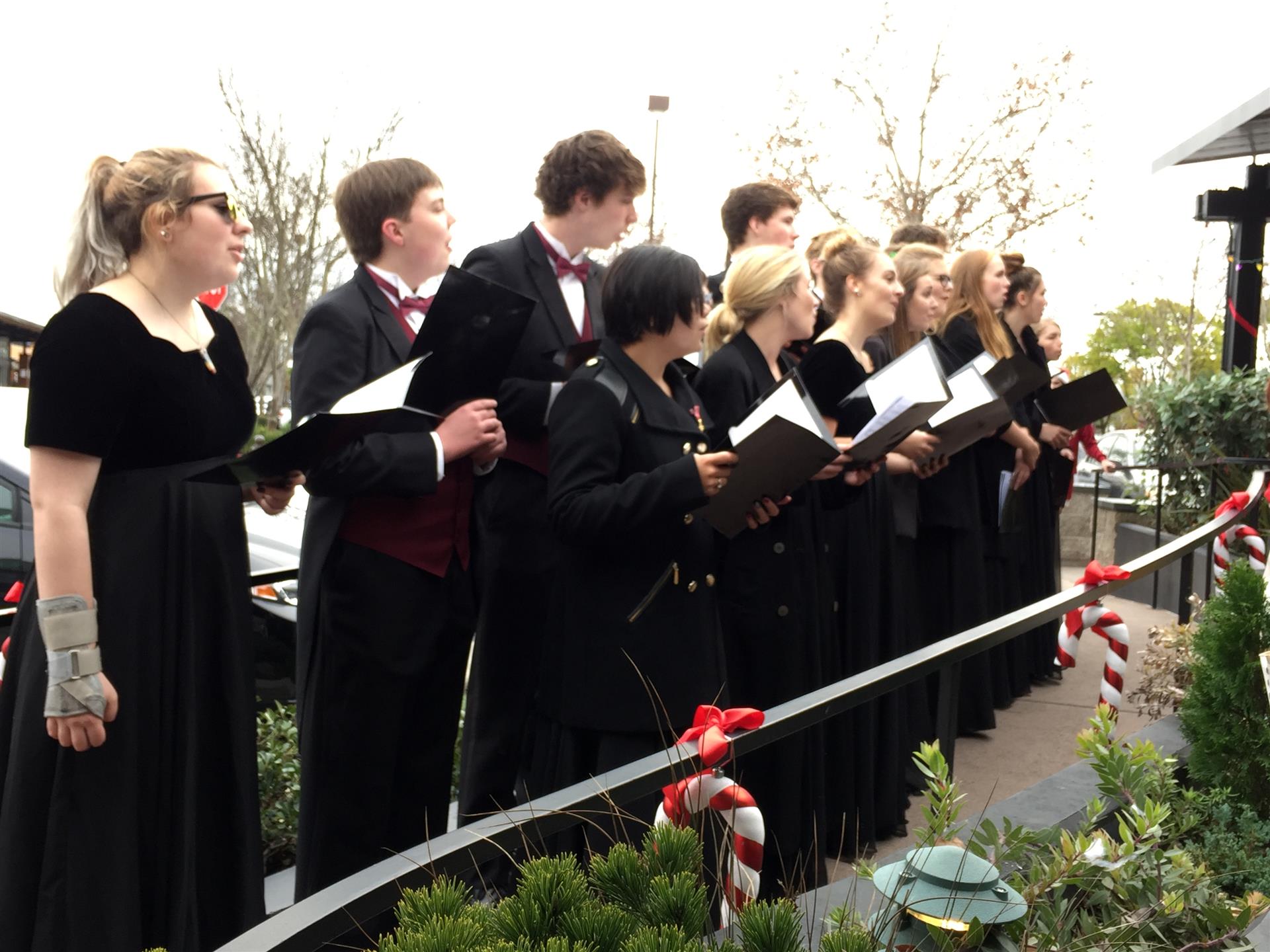 A group of people are singing in a choir outside