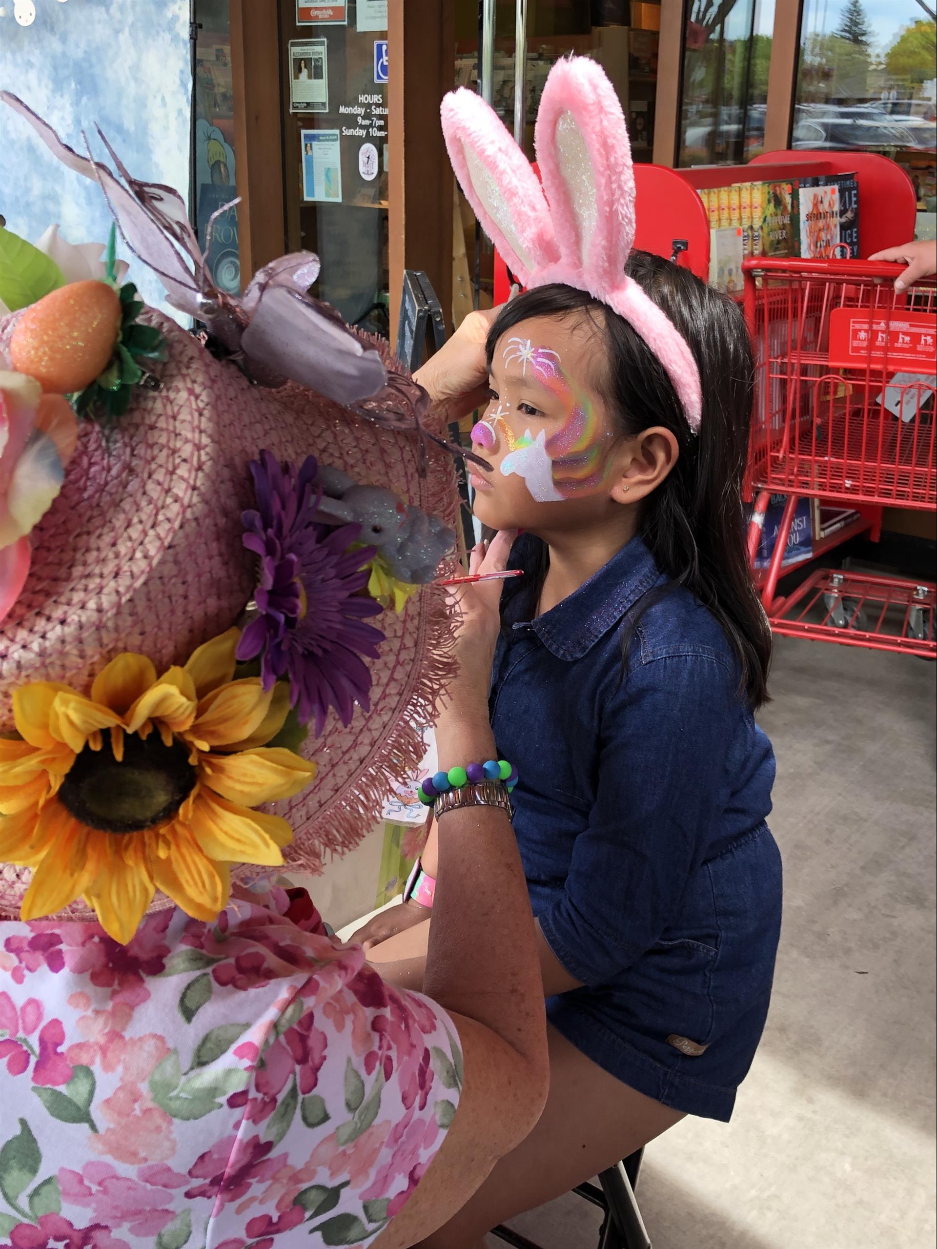 A little girl with bunny ears painted on her face