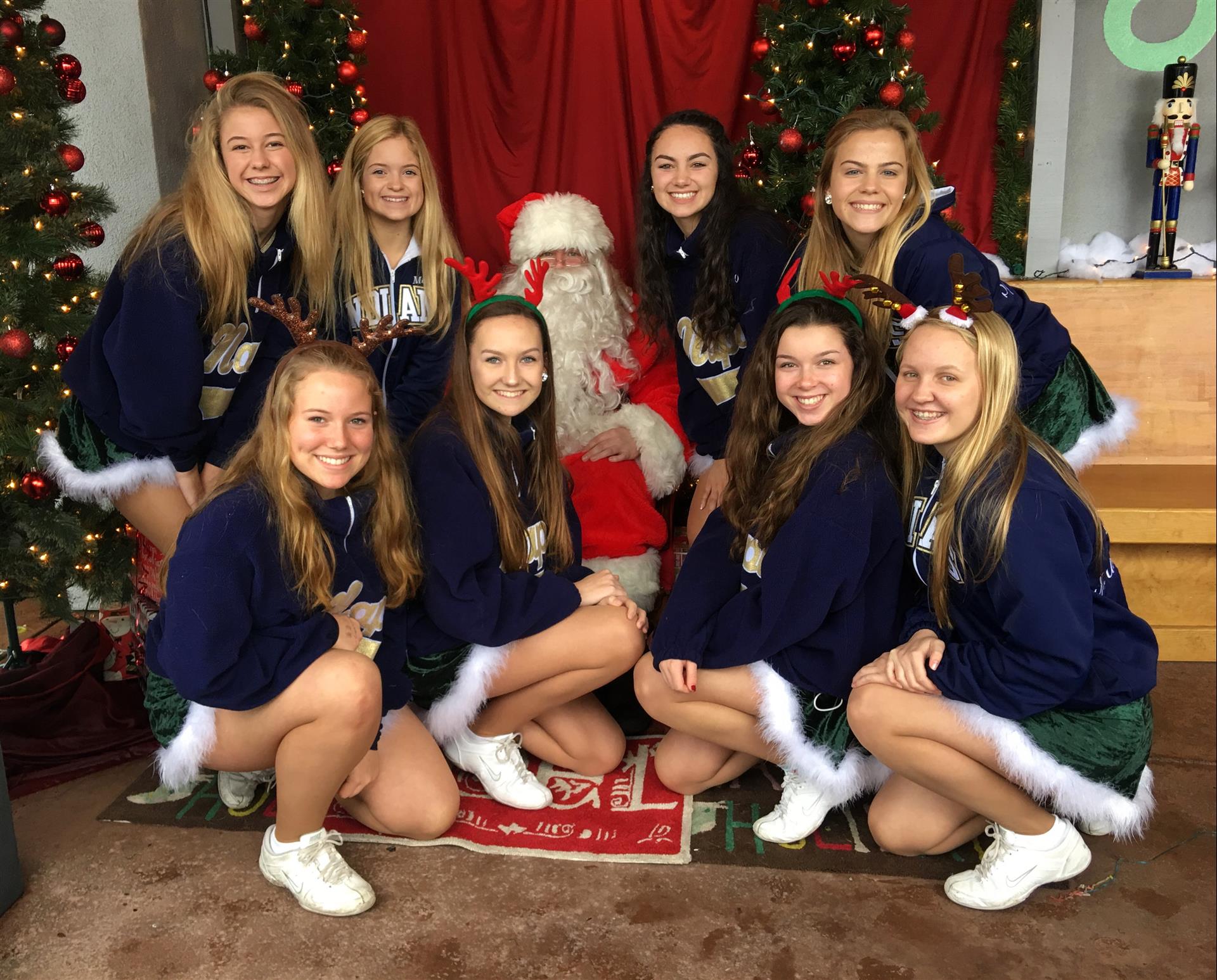 A group of girls are posing for a picture with santa claus