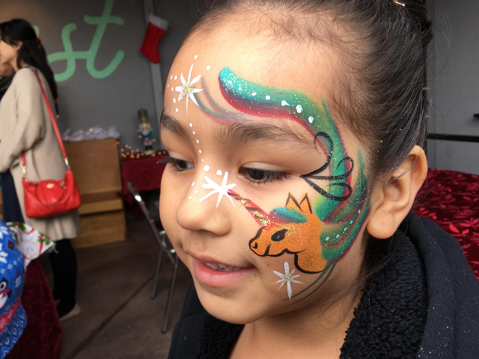 A little girl with a unicorn painted on her face