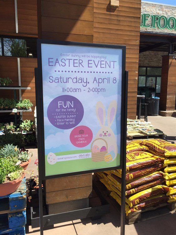 A sign for an easter event is displayed in front of a store.