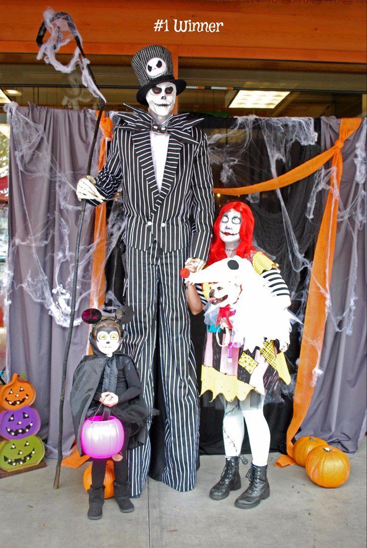 A group of people dressed in halloween costumes are posing for a picture.