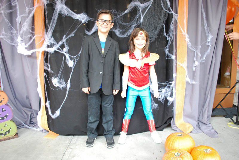 A boy and a girl in costumes are posing for a picture