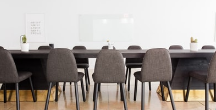A conference room with a long table and chairs.