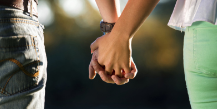 A man and a woman are holding hands and looking at each other.