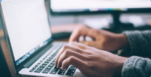 A person is typing on a laptop computer.
