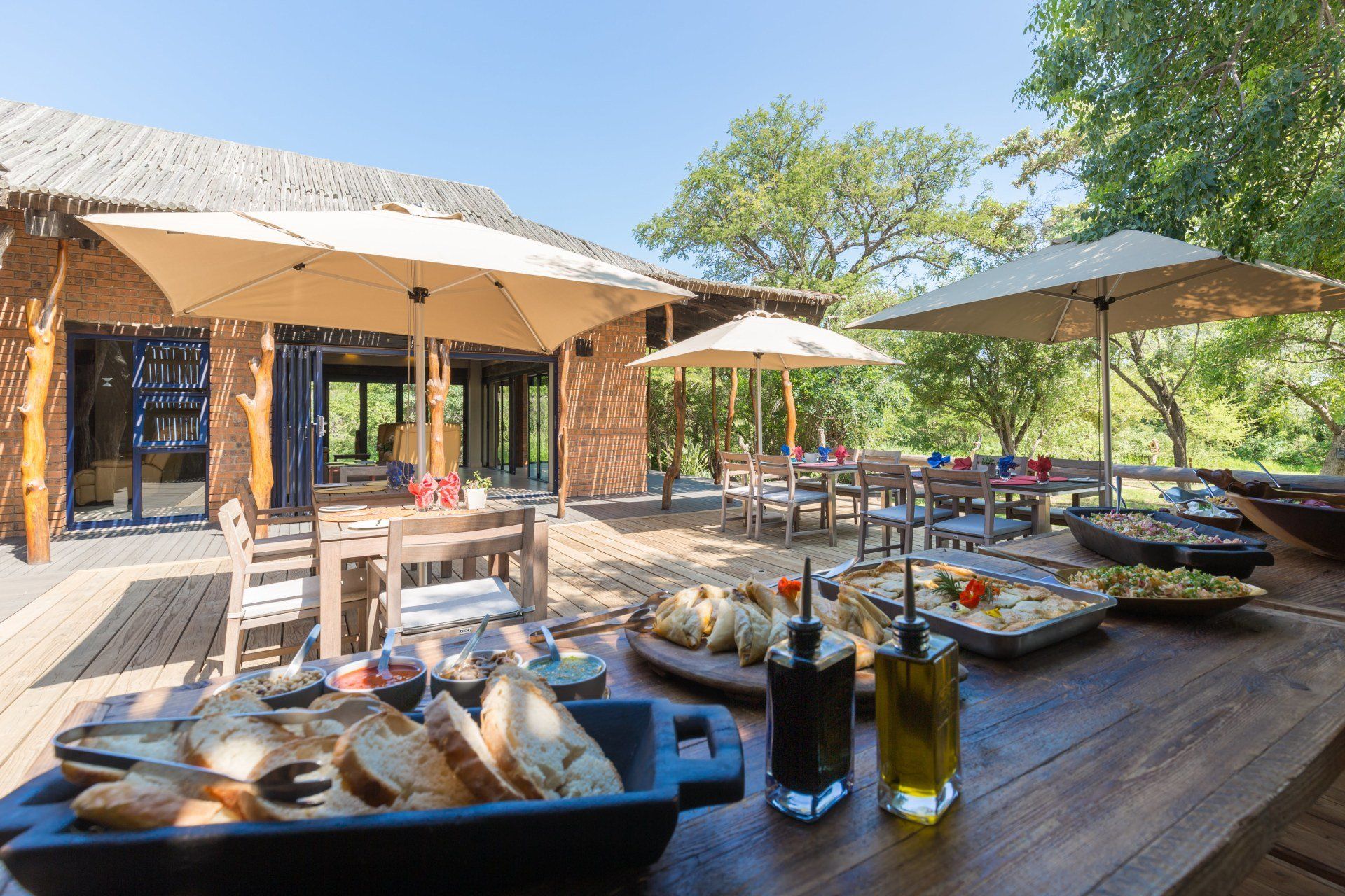 Outdoor dining table with drinks and snacks on a sunny patio at a rustic resort