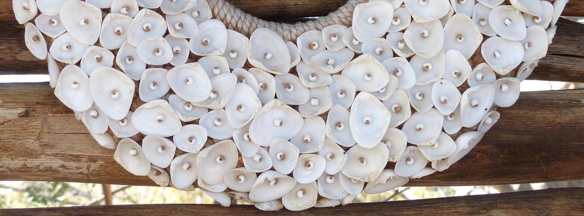 White seashell wreath on weathered wooden slats