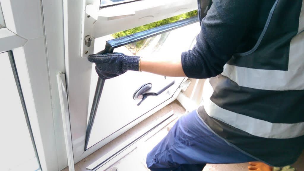 Glazier fitting lower half of glass door
