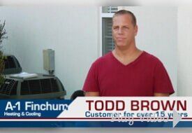 Man in red shirt stands outside near an HVAC unit; text labels: 