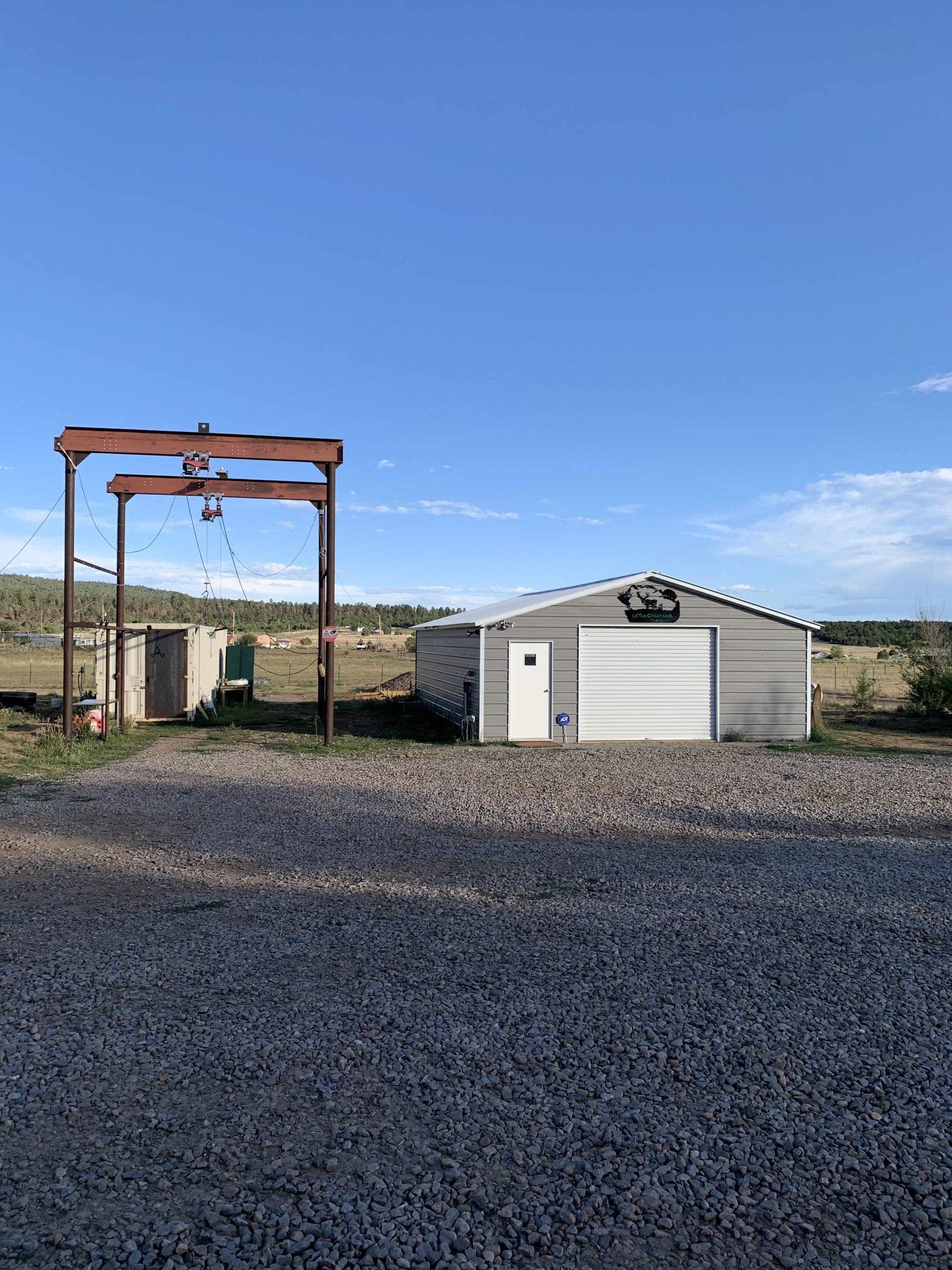 A garage with a white door and a crane in front of it.