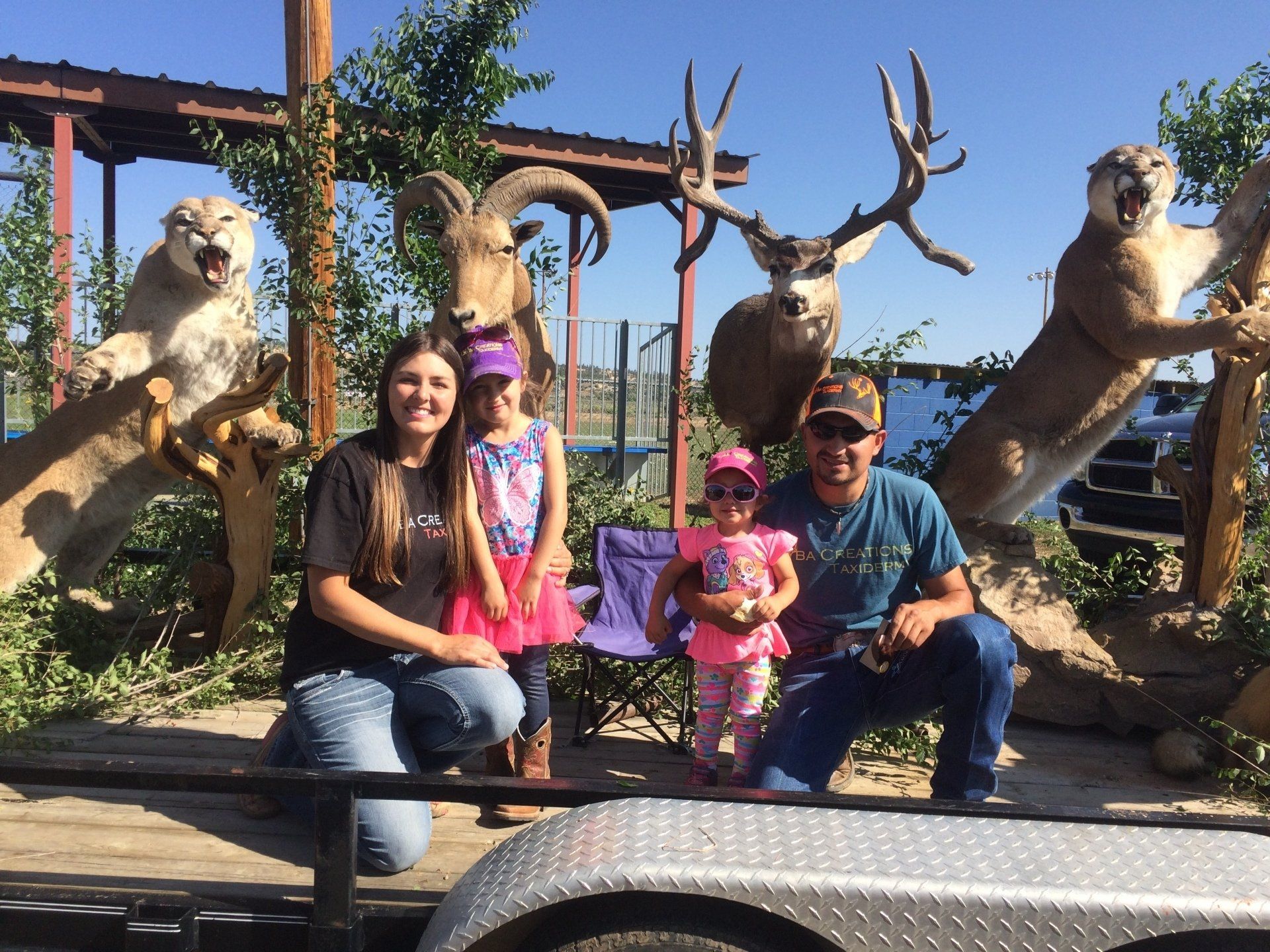 A family posing for a picture in front of stuffed animals