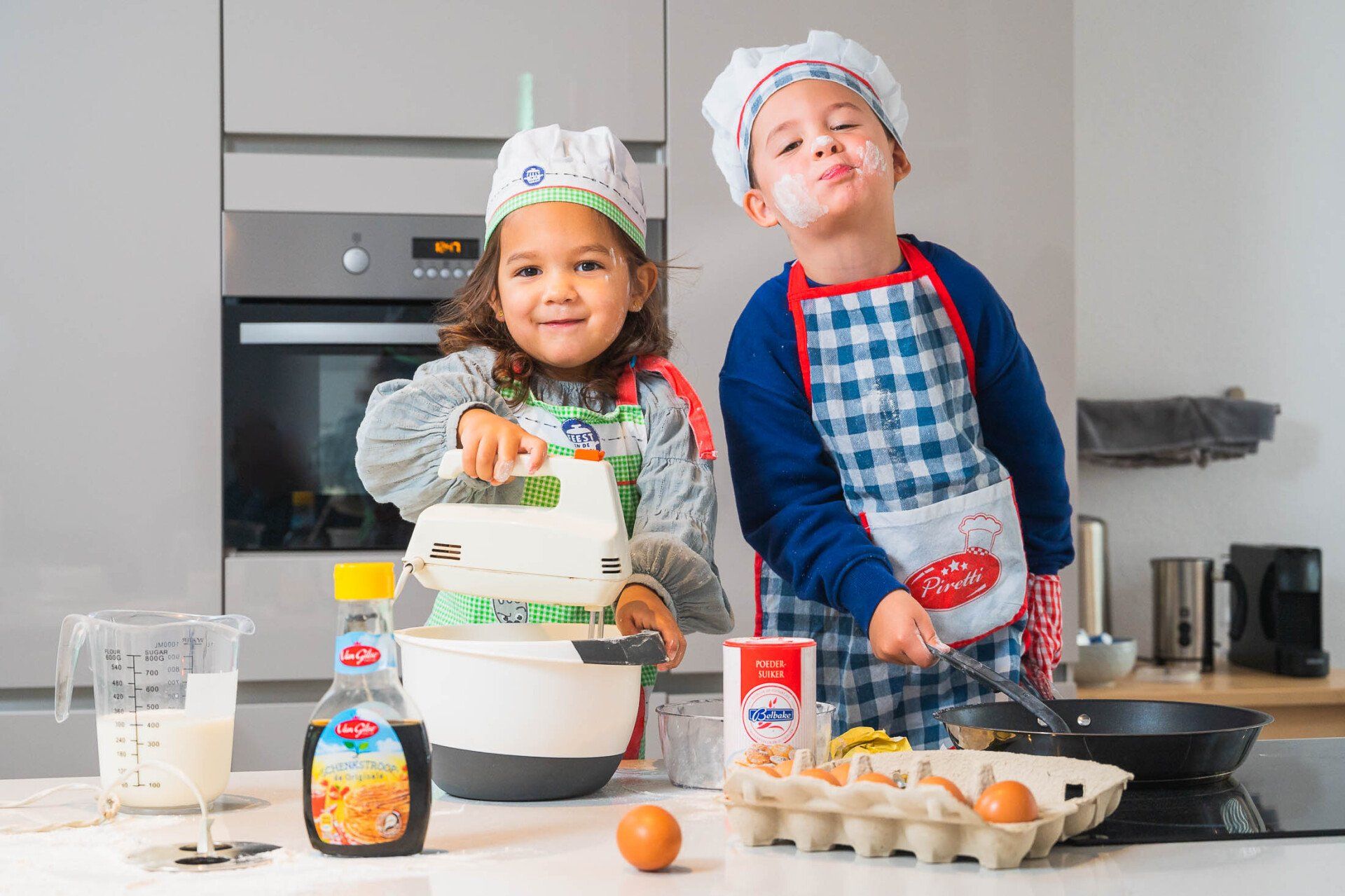 Een jongen en een meisje staan naast elkaar in de keuken eten te bereiden.