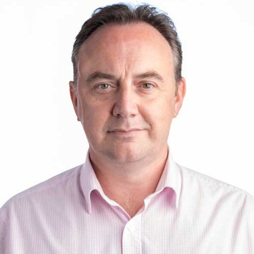 Portrait of a man in a light pink shirt against a white background