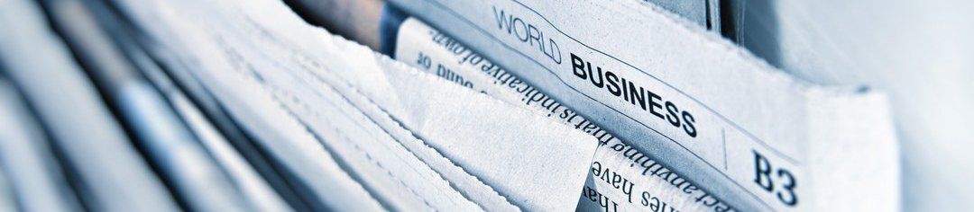 Stack of white business papers or files in a folder, with labels and tabs visible.