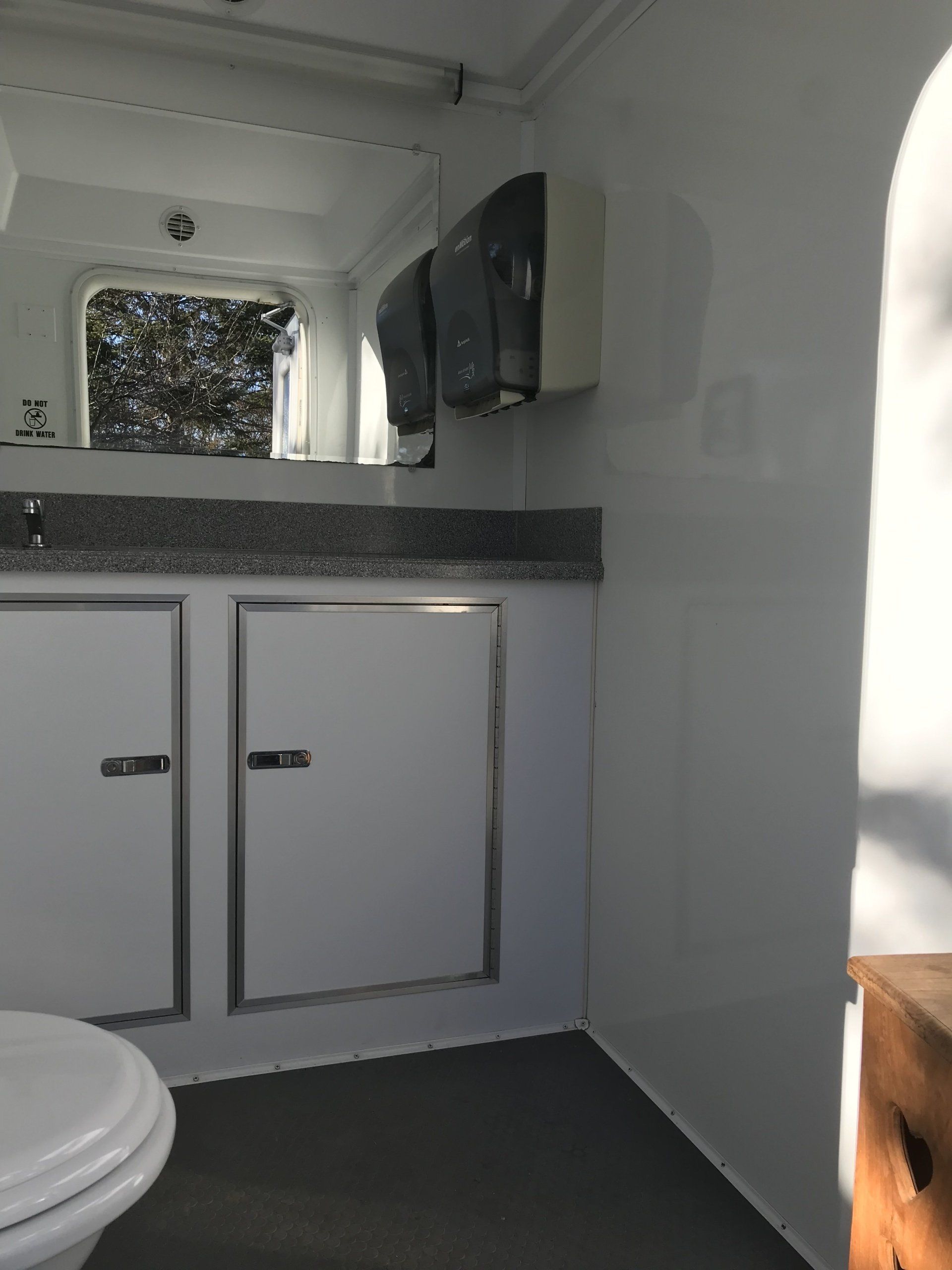 A bathroom with a toilet a sink and a mirror