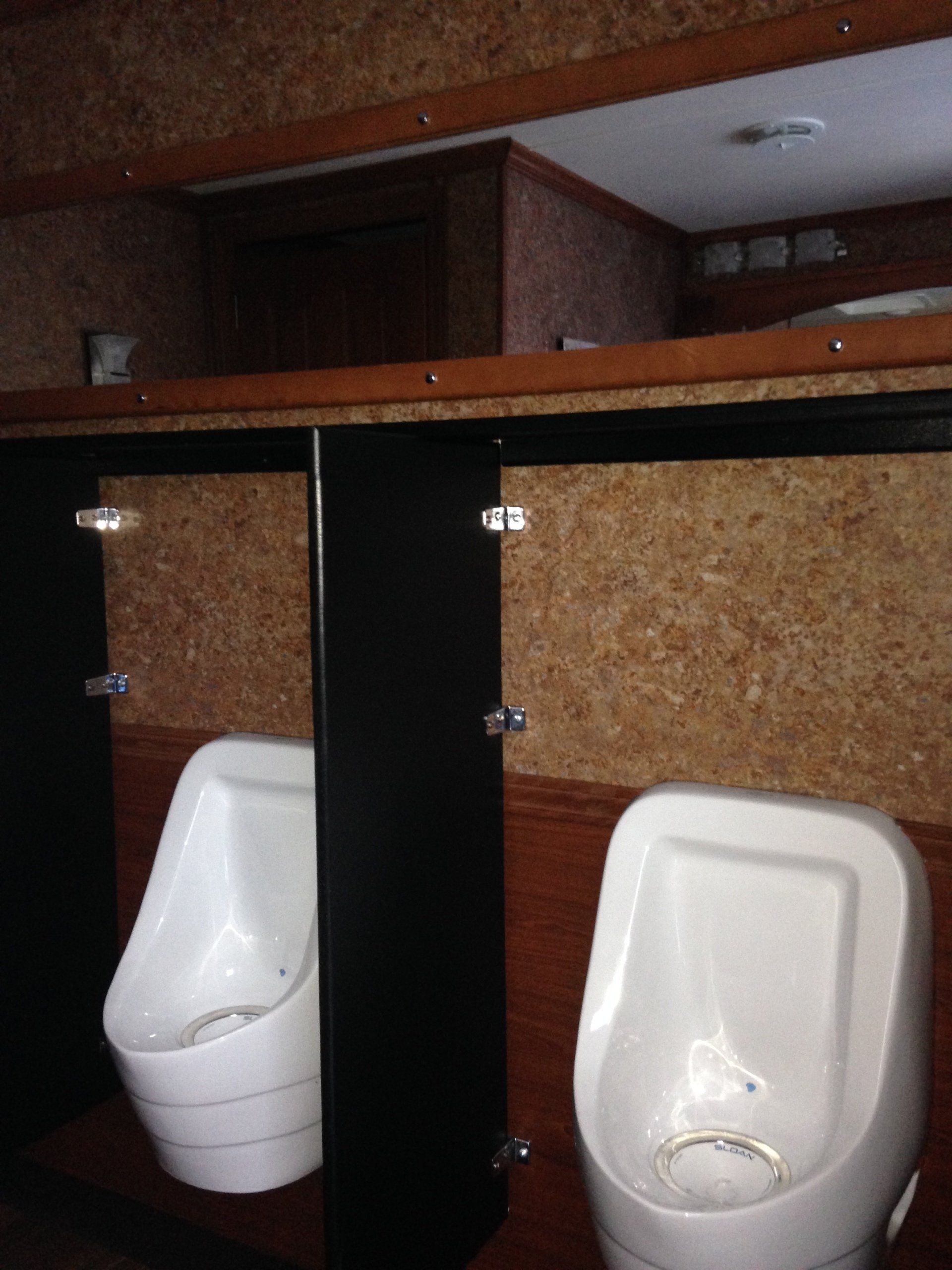 A bathroom with two urinals and two toilets