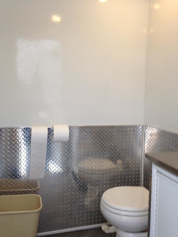 A bathroom with a toilet and a trash can