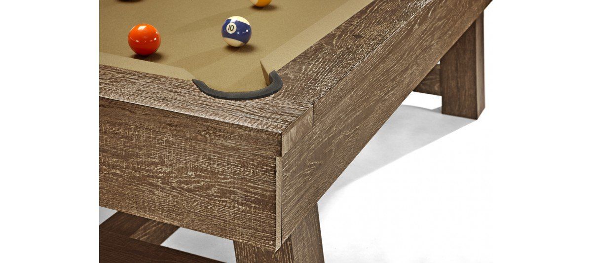 Two billiard balls on a weathered wooden pool table corner with a cue stick nearby