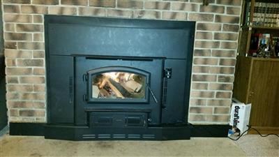 A brick fireplace with a wood stove in it