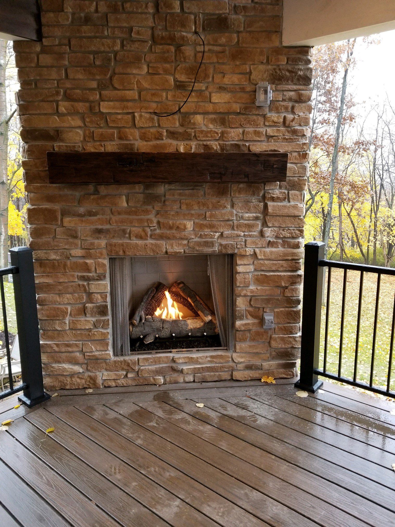A brick fireplace is sitting on top of a wooden deck.