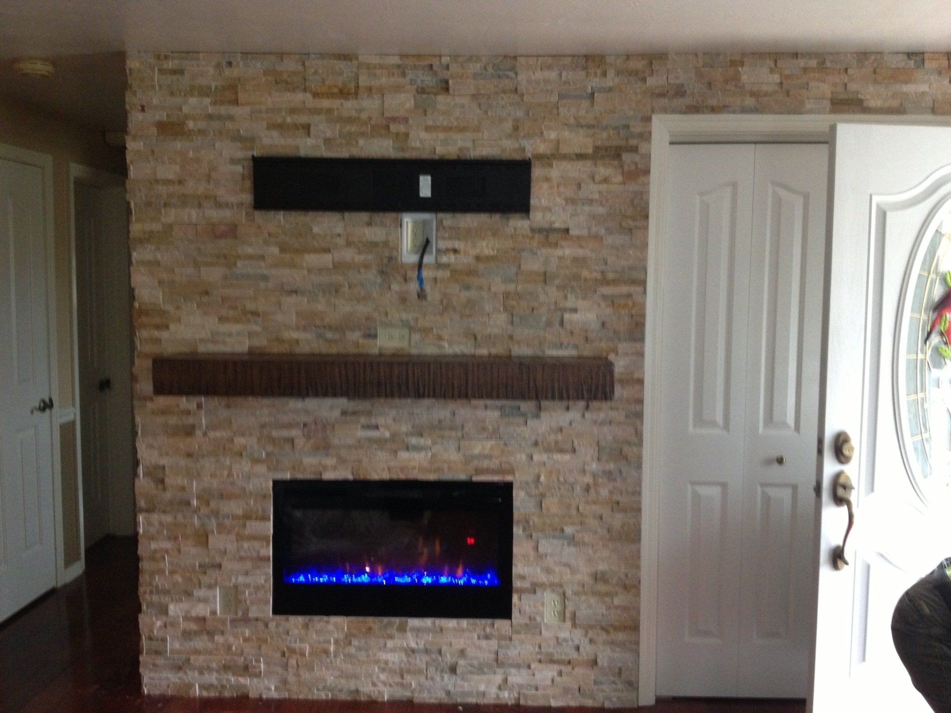 A living room with a fireplace and a brick wall.
