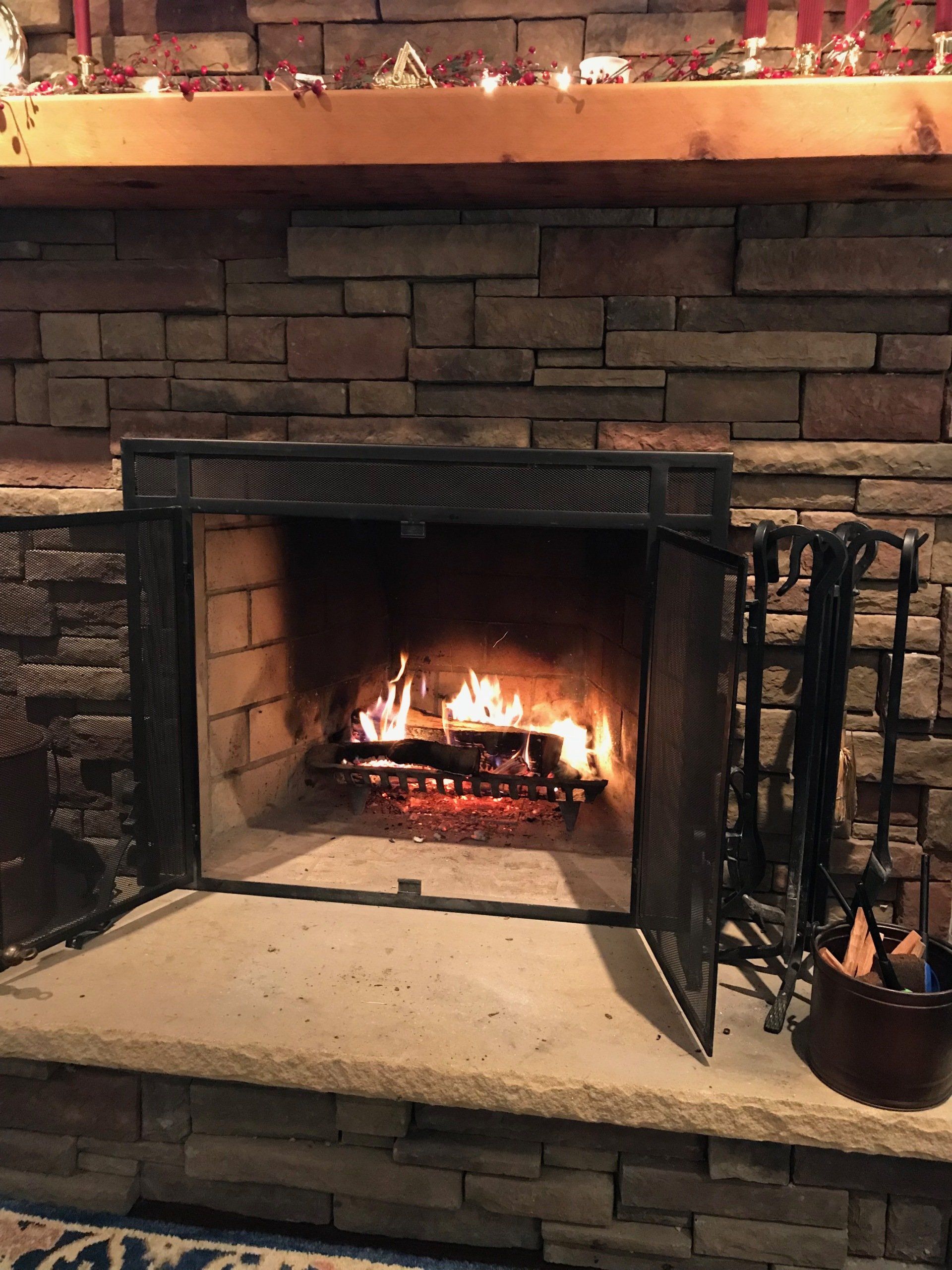 A fireplace with the door open and a brick wall